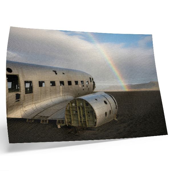Poster Een metalen vliegtuigwrak met een regenboog op de achtergrond.