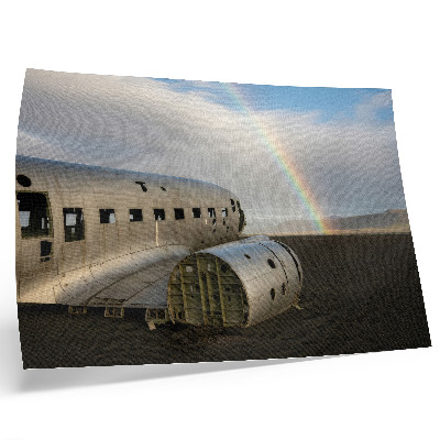 Poster Een metalen vliegtuigwrak met een regenboog op de achtergrond.