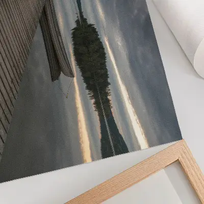 Poster met een rustgevende sfeer van de zee, een boot, een bos en wolken