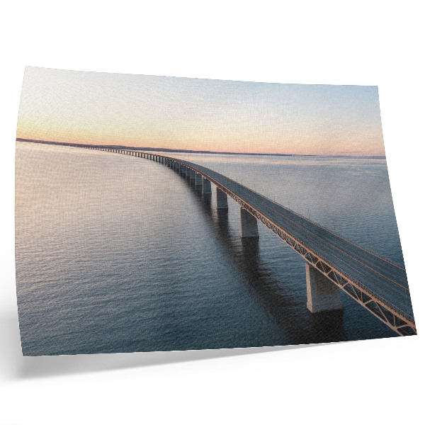 Poster Een brug over een kalme zee bij zonsondergang.