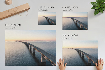 Poster Een brug over een kalme zee bij zonsondergang.