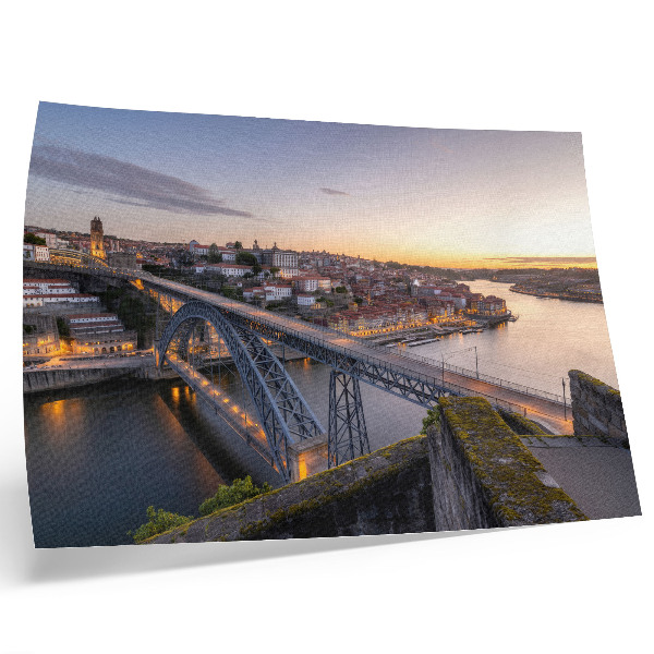 Poster De brug tegen de achtergrond van de ondergaande zon en de stad.