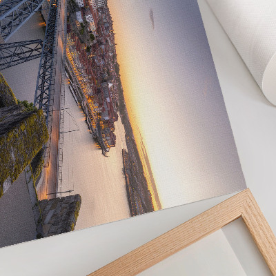 Poster De brug tegen de achtergrond van de ondergaande zon en de stad.