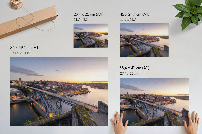 Poster De brug tegen de achtergrond van de ondergaande zon en de stad.