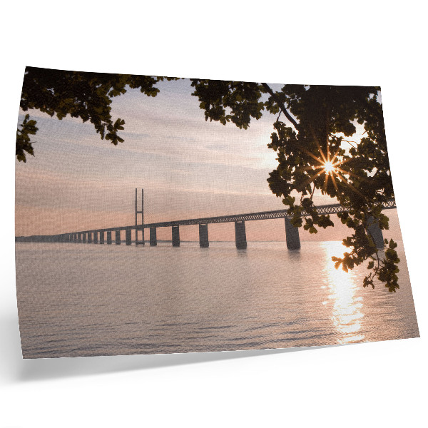 Moderne decoratieve poster Een pittoreske brug bij zonsondergang over het water.