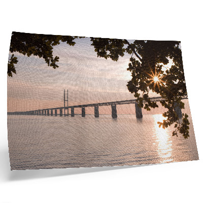 Moderne decoratieve poster Een pittoreske brug bij zonsondergang over het water.