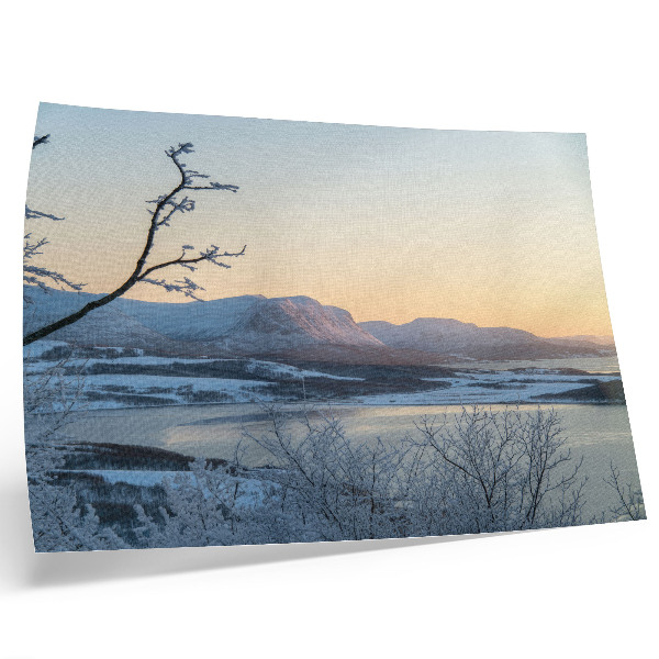 Poster Winterlandschap met bergen, water en bomen in de schemering.