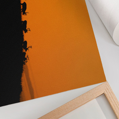 Moderne decoratieve poster Silhouetten van herten op een heuvel met een oranje achtergrond.