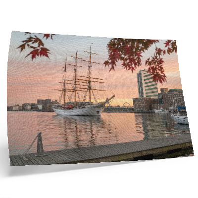 Poster Een zeilschip bij zonsondergang, een vredig panorama van de stad.