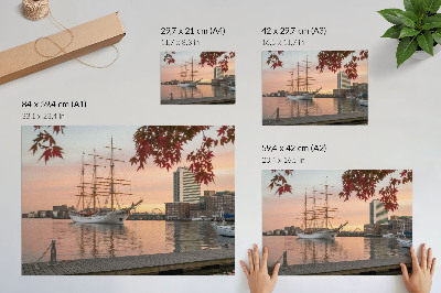Poster Een zeilschip bij zonsondergang, een vredig panorama van de stad.