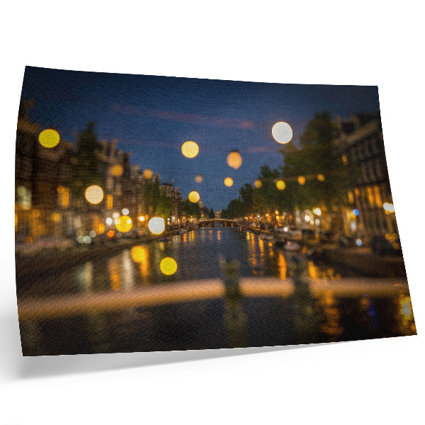 Stijlvolle wandposter Een charmante stad 's nachts, de lichtjes weerspiegeld in het water.
