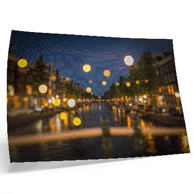 Stijlvolle wandposter Een charmante stad 's nachts, de lichtjes weerspiegeld in het water.