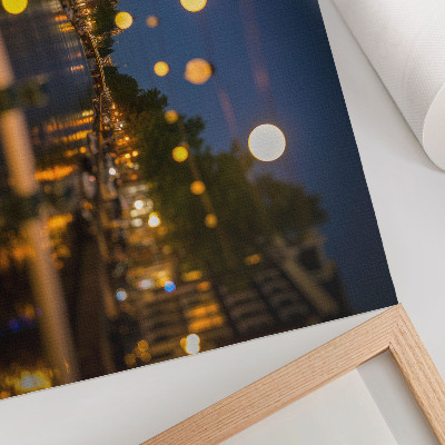 Stijlvolle wandposter Een charmante stad 's nachts, de lichtjes weerspiegeld in het water.