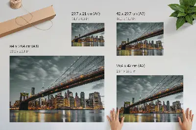 Stijlvolle wandposter Avondpanorama met een verlichte stadsbrug boven het water