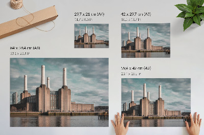 Stijlvolle wandposter Een indrukwekkend gebouw met schoorstenen boven de rivier.