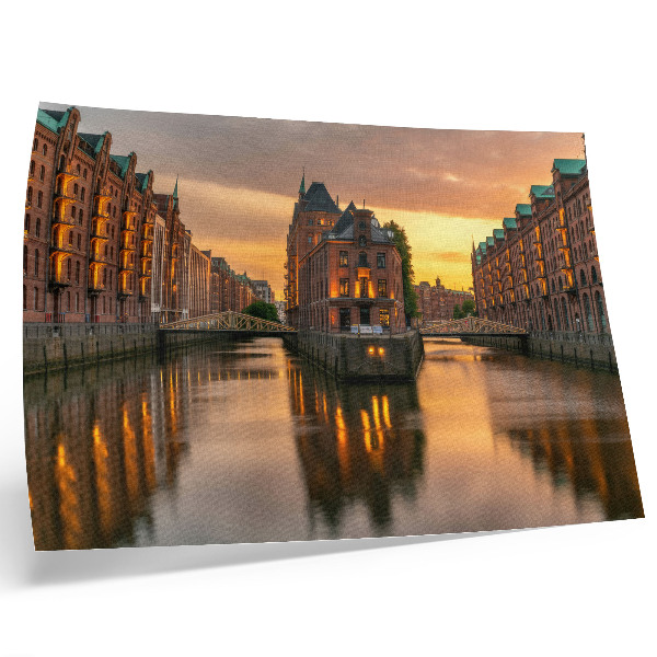 Poster Rustig water, bakstenen gebouwen, warm licht