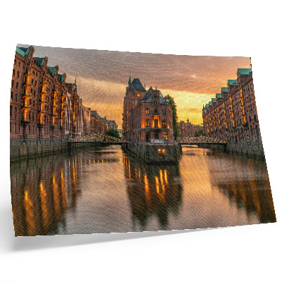Poster Rustig water, bakstenen gebouwen, warm licht