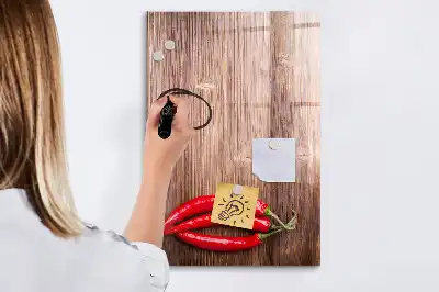 Magnetisch glazen memobord met afbeelding van chilipepers op een houten plank