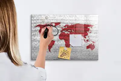 Magnetisch glazen schrijfbord met print van een wereldkaart op een bakstenen muur