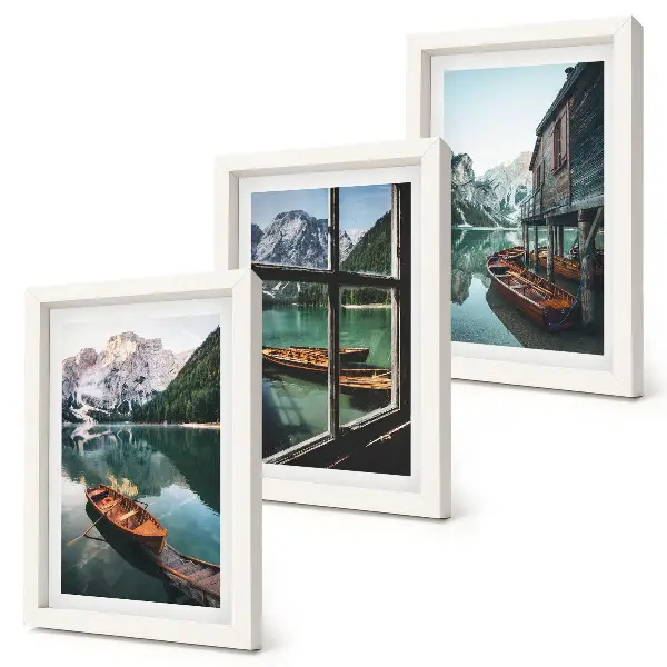 Set van ingelijste schilderijen met uitzicht op een bergmeer met boten en een huis aan het water