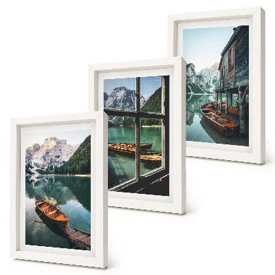 Set van ingelijste schilderijen Uitzicht op een bergmeer met boten en een huis aan het water.