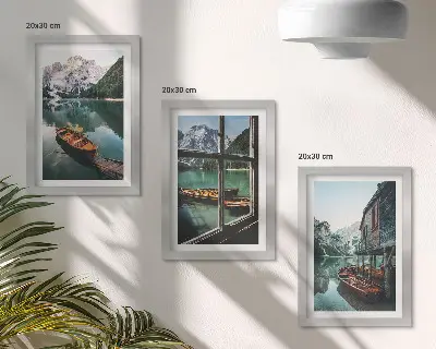 Set van ingelijste schilderijen met uitzicht op een bergmeer met boten en een huis aan het water
