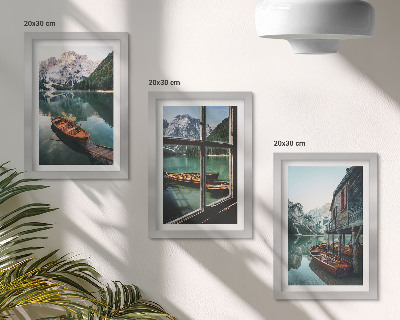 Set van ingelijste schilderijen Uitzicht op een bergmeer met boten en een huis aan het water.