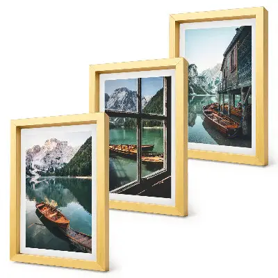 Set van ingelijste schilderijen met uitzicht op een bergmeer met boten en een huis aan het water