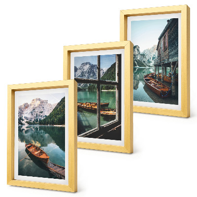 Set van ingelijste schilderijen Uitzicht op een bergmeer met boten en een huis aan het water.