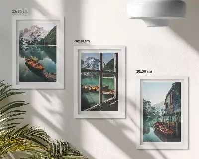 Set van ingelijste schilderijen met uitzicht op een bergmeer met boten en een huis aan het water