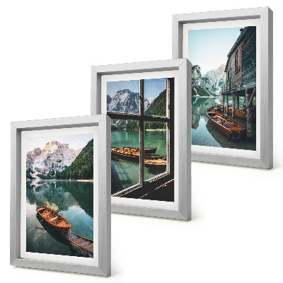 Set van ingelijste schilderijen Uitzicht op een bergmeer met boten en een huis aan het water.