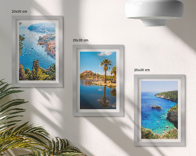 Set van ingelijste schilderijen Uitzicht op zee met palmbomen en blauw water.