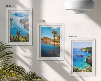Set van ingelijste schilderijen Uitzicht op zee met palmbomen en blauw water.