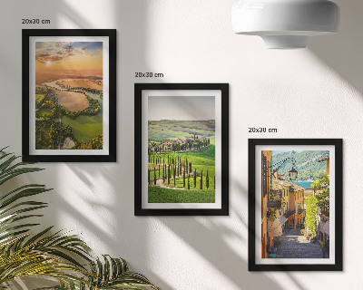 Set van ingelijste schilderijen Italiaanse landschappen met een rivier, heuvels en een stadsstraat.