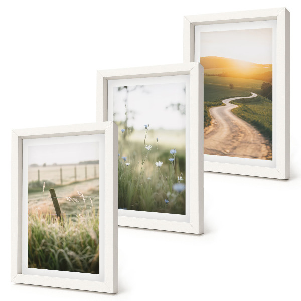 Set van ingelijste schilderijen Landschap met een weide, een weg en een zonsondergang.