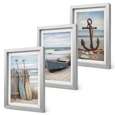 Set van ingelijste schilderijen Een strand met een roeiboot en een anker in het zand.