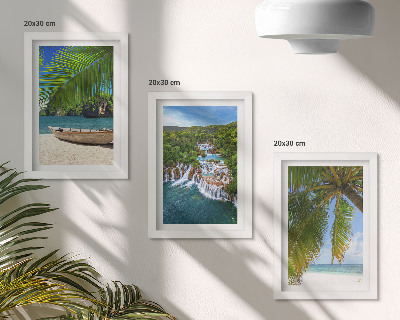 Set van ingelijste schilderijen Strand met boot, watervallen en palmbomen in de tropen.