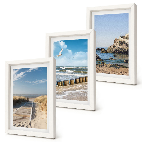 Set van ingelijste schilderijen Strand met houten pad, zee en kliffen aan zee.