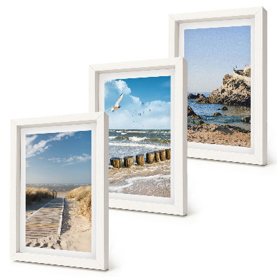 Set van ingelijste schilderijen Strand met houten pad, zee en kliffen aan zee.