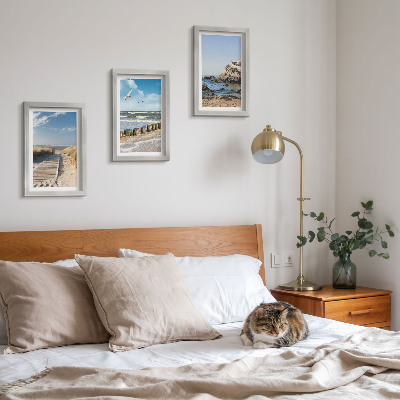 Set van ingelijste schilderijen Strand met houten pad, zee en kliffen aan zee.
