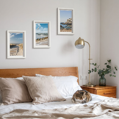 Set van ingelijste schilderijen Strand met houten pad, zee en kliffen aan zee.