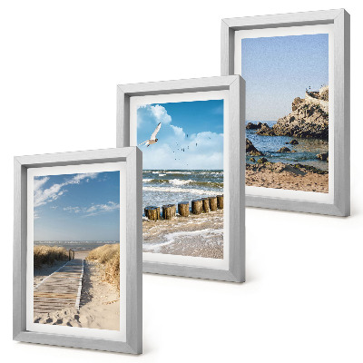 Set van ingelijste schilderijen Strand met houten pad, zee en kliffen aan zee.