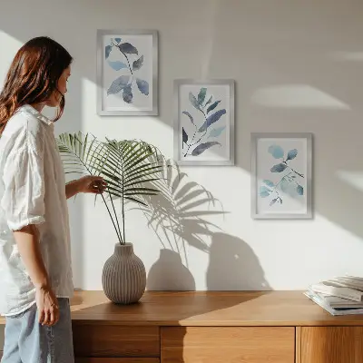 Set ingelijste schilderijen met blauwe bladeren op een lichte achtergrond in aquarel-stijl