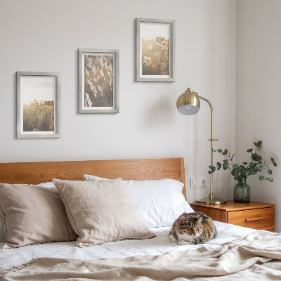 Gallery wall Een landschap met grassen en bloemen in warme tinten.