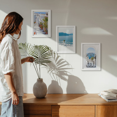 Gallery wall Witte trap met planten, uitzicht op zee en poort.