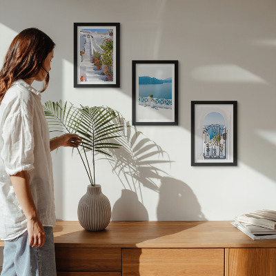 Gallery wall Witte trap met planten, uitzicht op zee en poort.