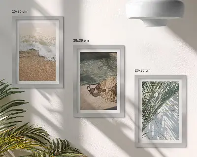 Gallery wall met afbeelding van een strandhoed en zonnebril tussen bladeren
