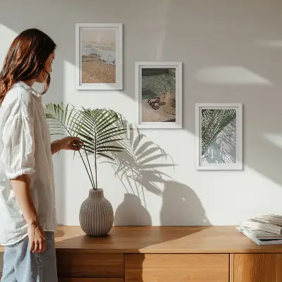 Gallery wall met afbeelding van een strandhoed en zonnebril tussen bladeren