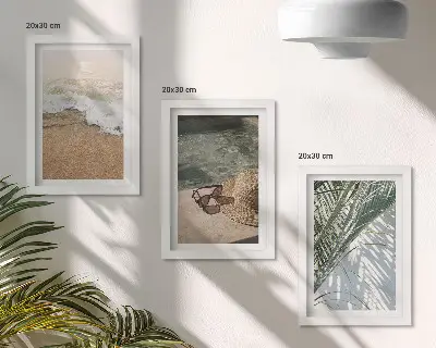 Gallery wall met afbeelding van een strandhoed en zonnebril tussen bladeren