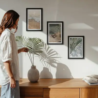 Gallery wall met afbeelding van een strandhoed en zonnebril tussen bladeren
